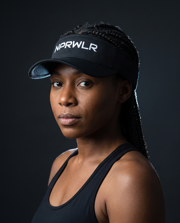 Model wearing the NPRWLR Visor in black, three-quarter view showing the open crown and curved brim