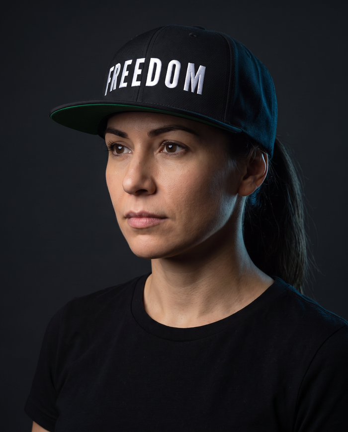 Model wearing the NPRWLR Freedom Snapback Hat in black, three-quarter view showing the flat brim